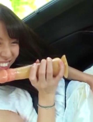 Young Japanese amateur sucks dildo while in the car